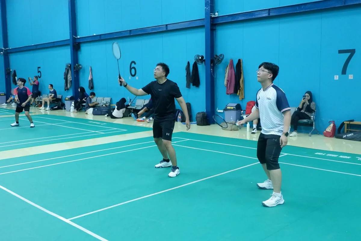 Dua pemain bersiap dalam pertandingan ganda.