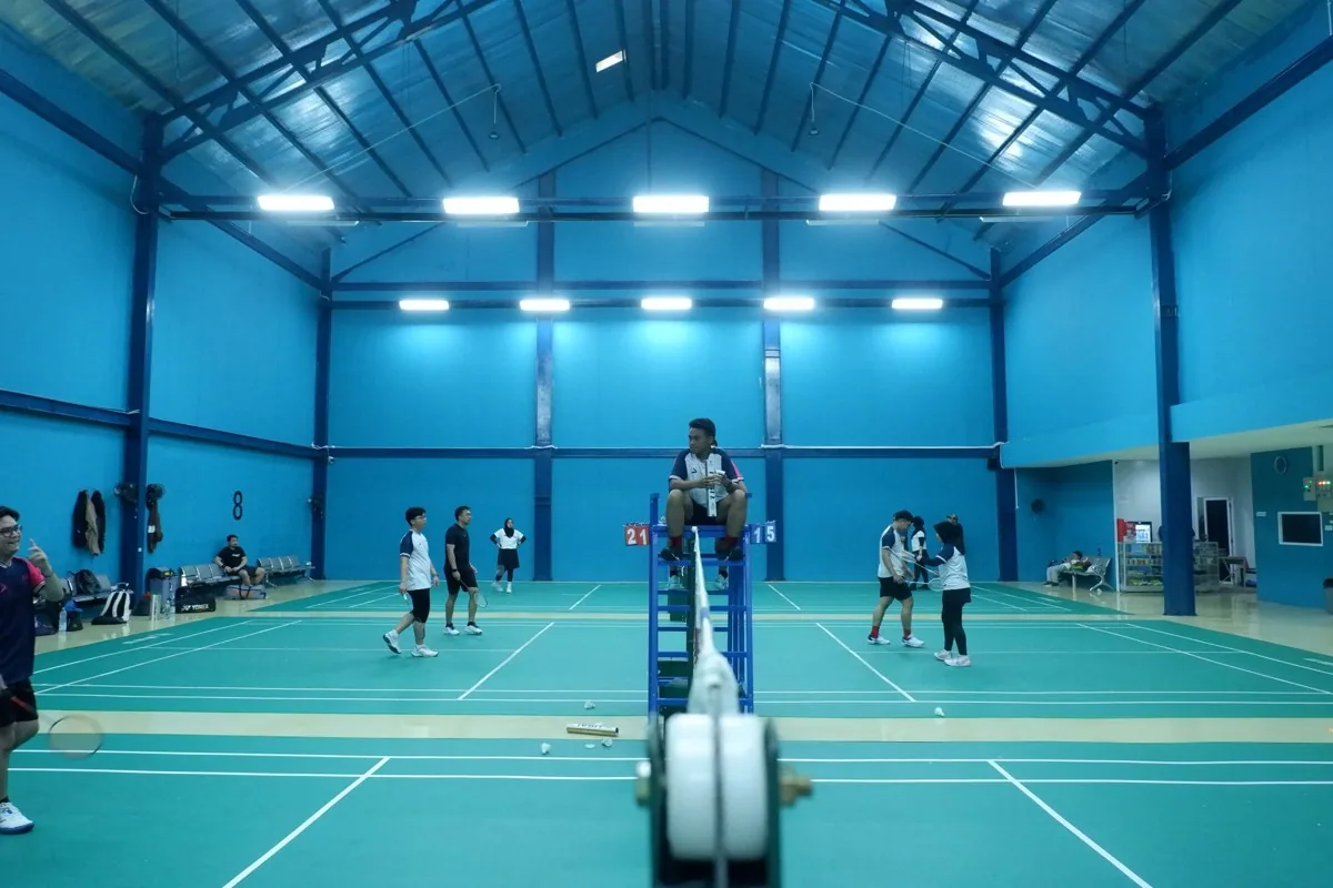 Suasana lapangan dengan wasit di tengah.