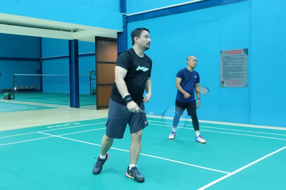 Dua pemain bersiap menerima pengembalian kok.